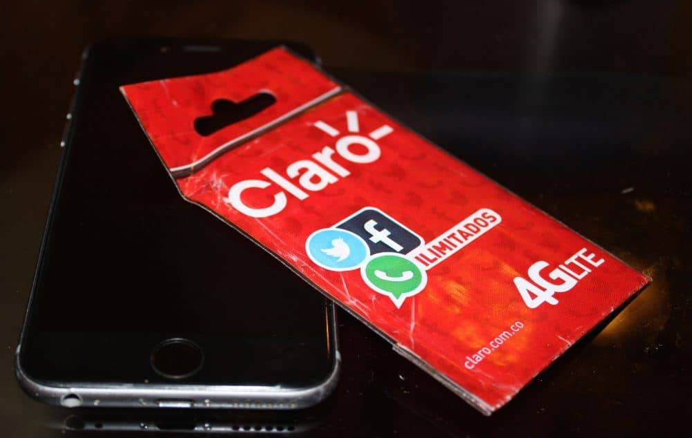 Photo of a Claro SIM card packet partially sitting on a smartphone.