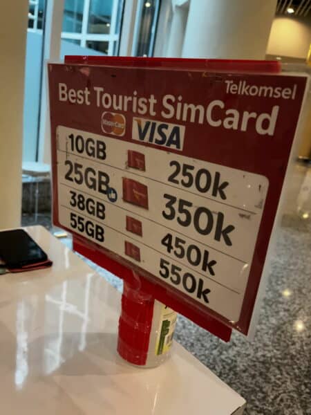 Sign advertising the "best tourist simcard" at Bali Airport in Indonesia, with prices for different data packages