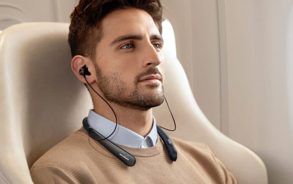 Man on plane wearing Life NC headphones