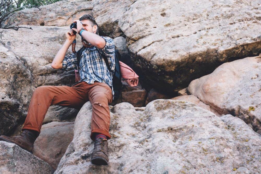 Man holding camera on rocks