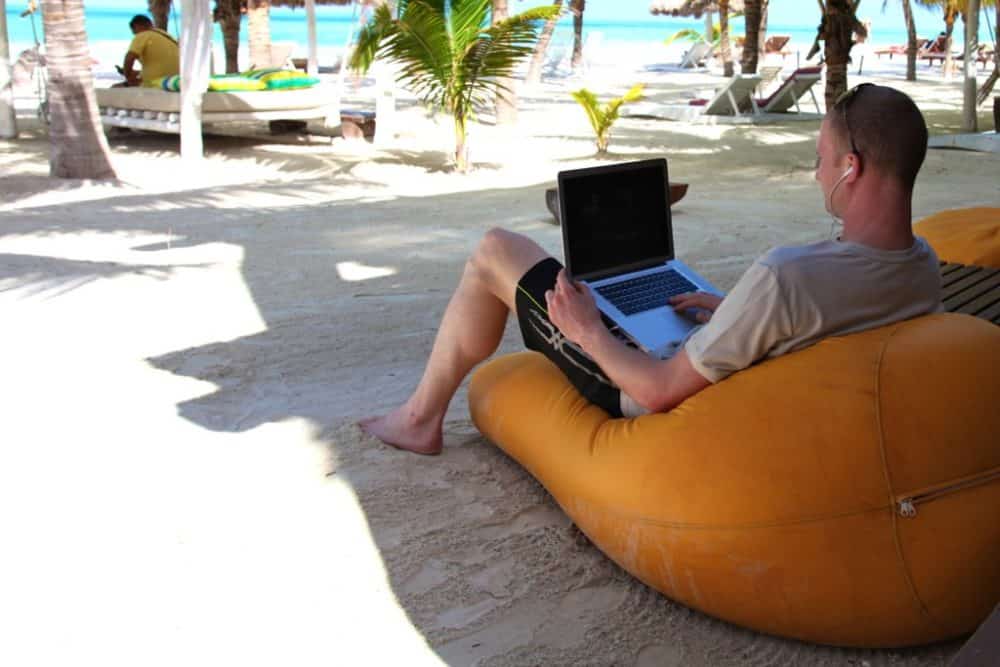 Man using laptop on beach