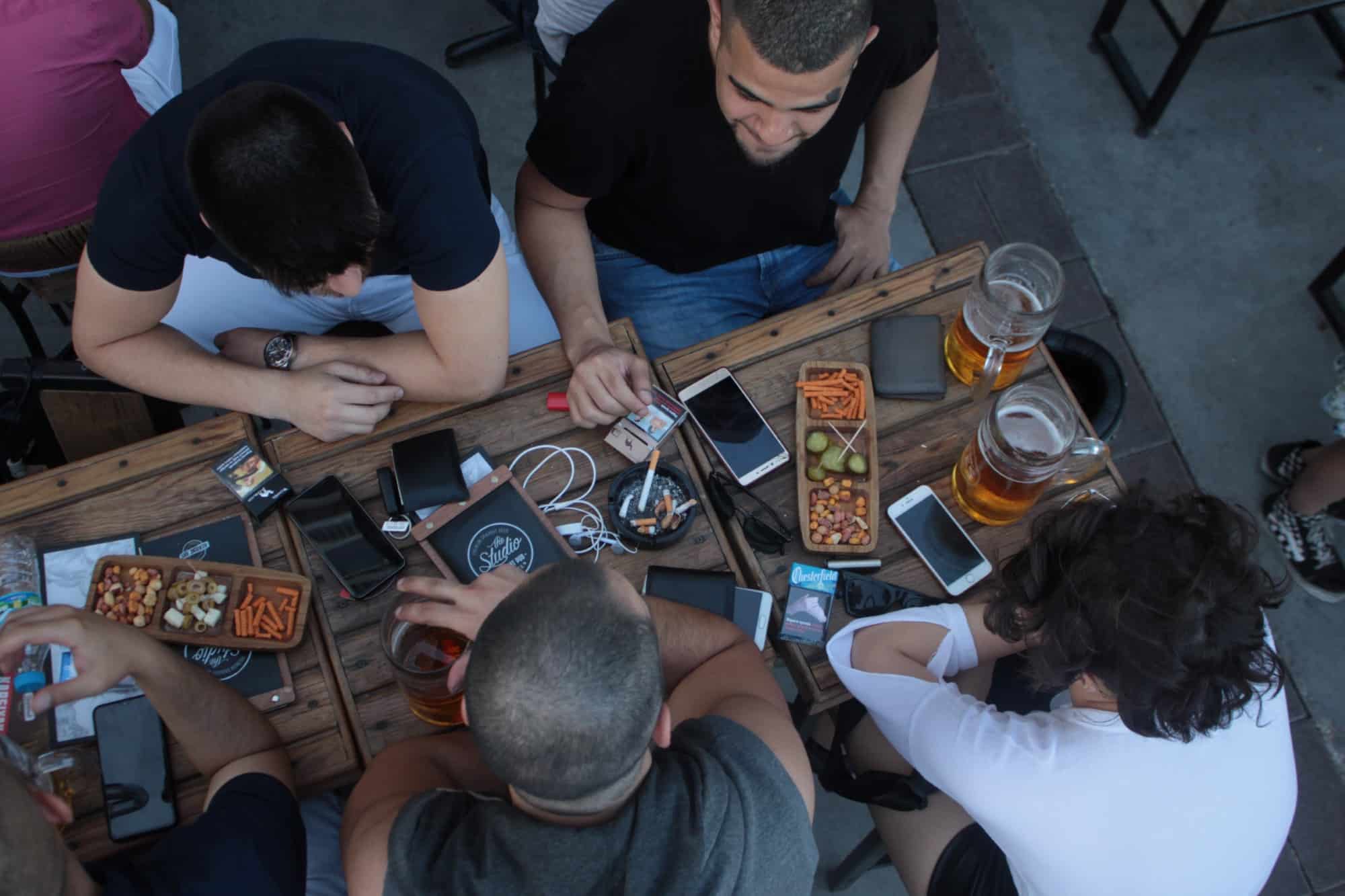 People sitting around table with phones and food