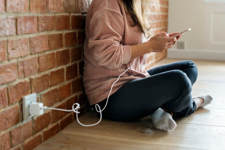 Person charging phone from wall socket