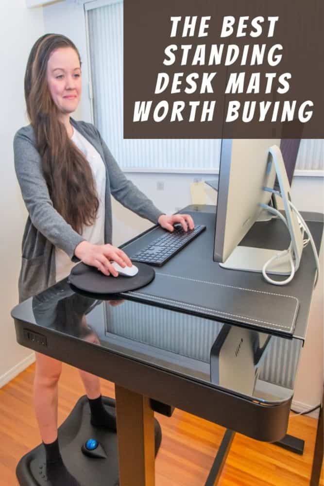 Woman in partial business attire in front of standing desk, with text "The Best Standing Desk Mats Worth Buying" at top right