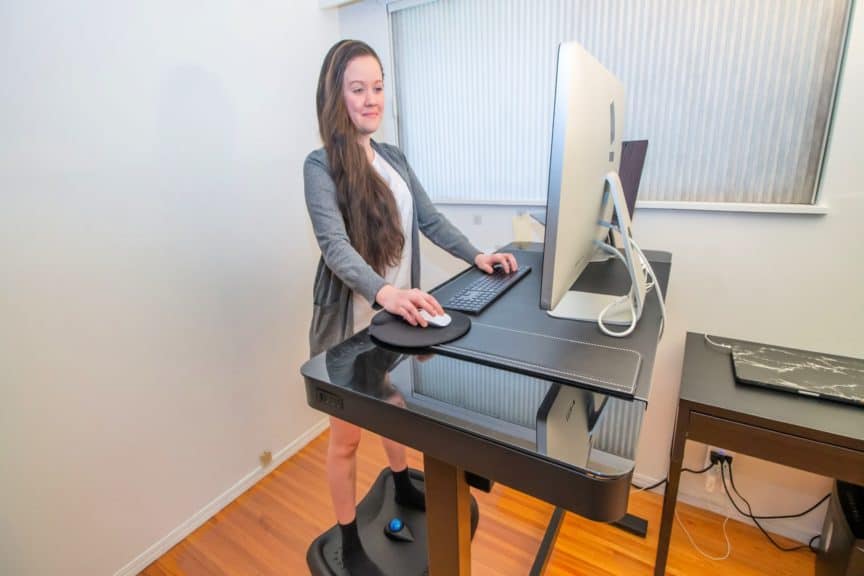 Woman in partial business attire in front of standing desk