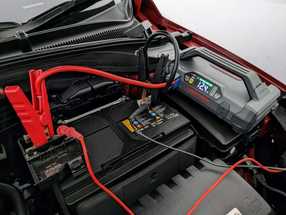 Lokithor JA301 portable jump starter connected to car battery terminals