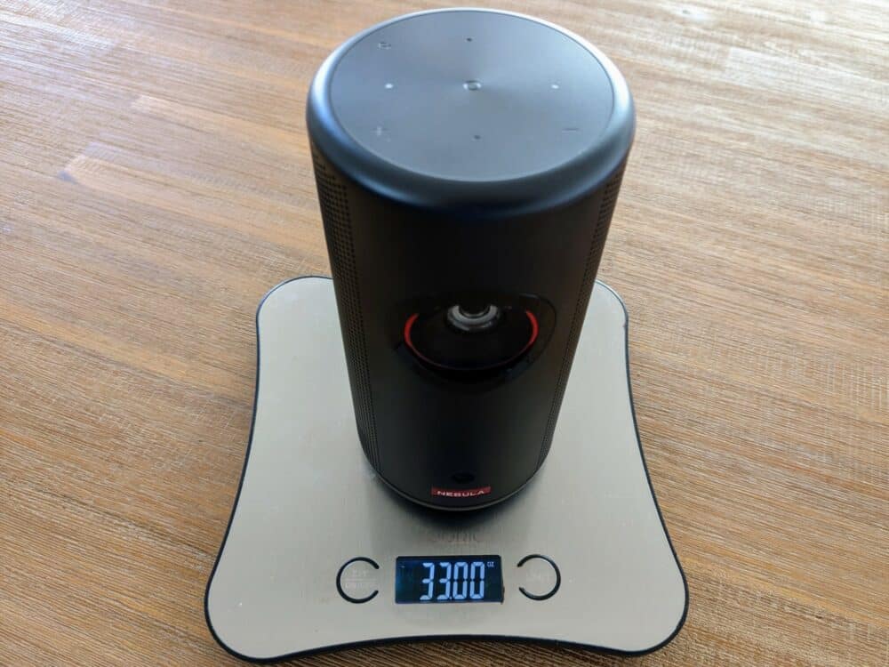 Nebula Capsule 3 Laser projector on kitchen scales, displaying 33.00oz weight