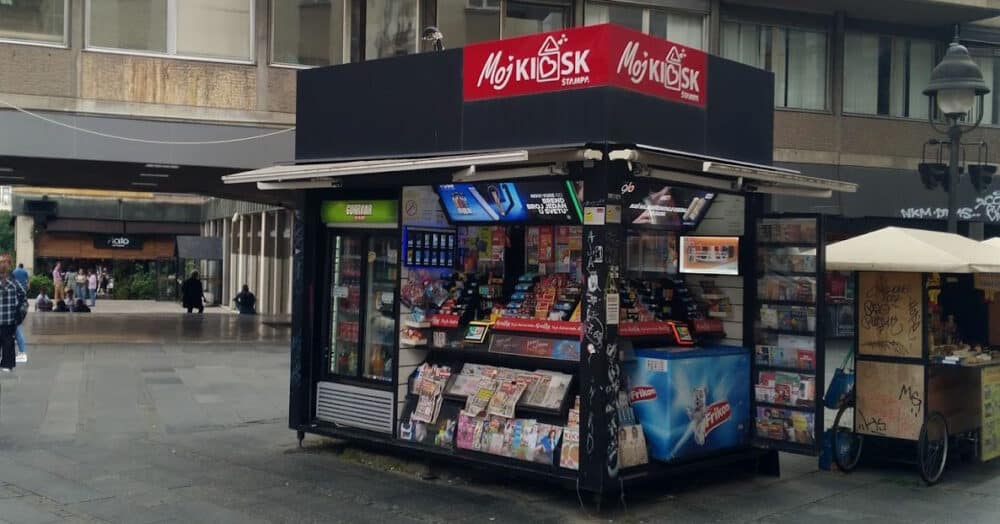 Kiosk in a plaza in Belgrade, Serbia, with magazines, snacks, and drinks on display 