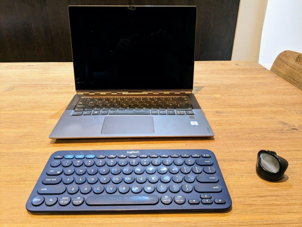 Small blue keyboard, laptop, and tiny mouse on wooden table