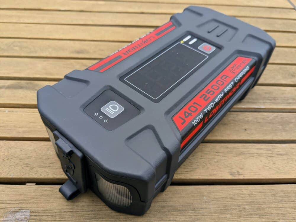 J401 portable jump starter sitting on an angle on a wooden table