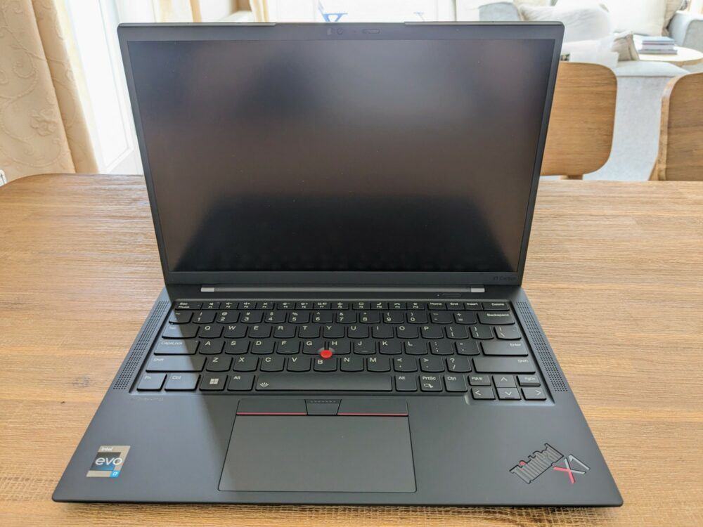 Lenovo Thinkpad X1 laptop open on wooden table with chairs behind