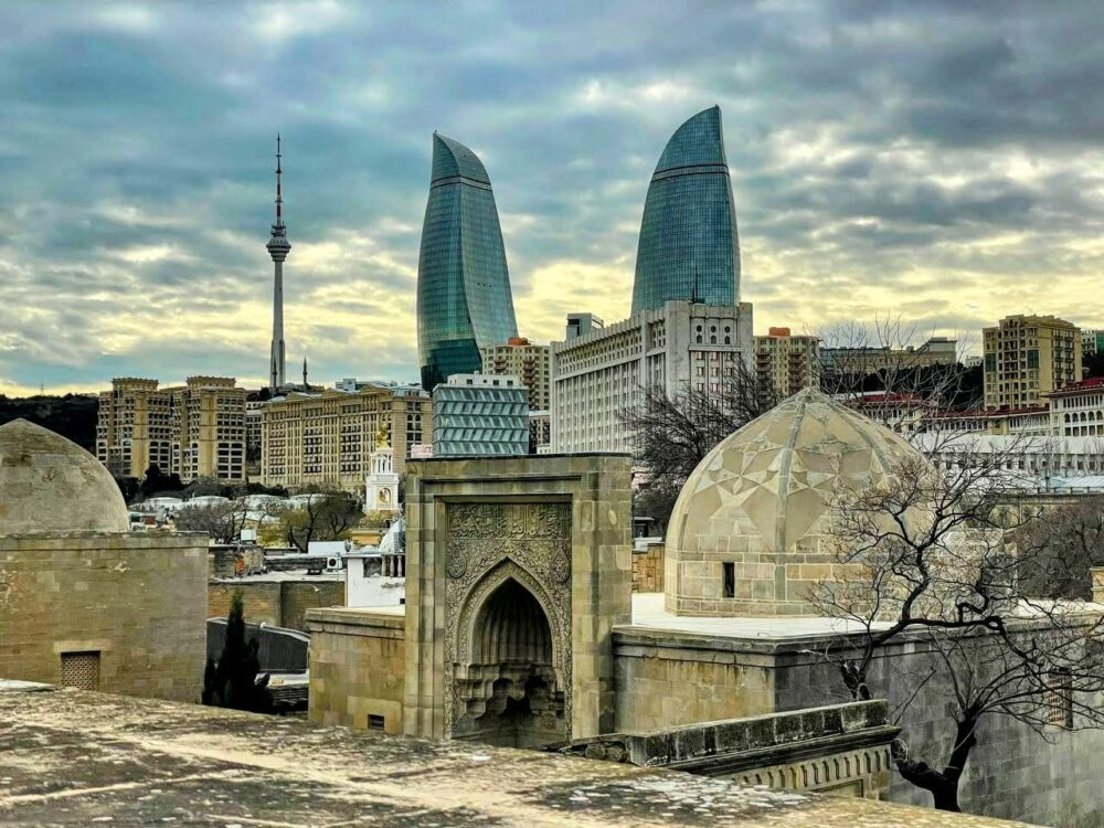 View over old buildings and archways towards modern buildings and tower in Baku, Azerbaijan