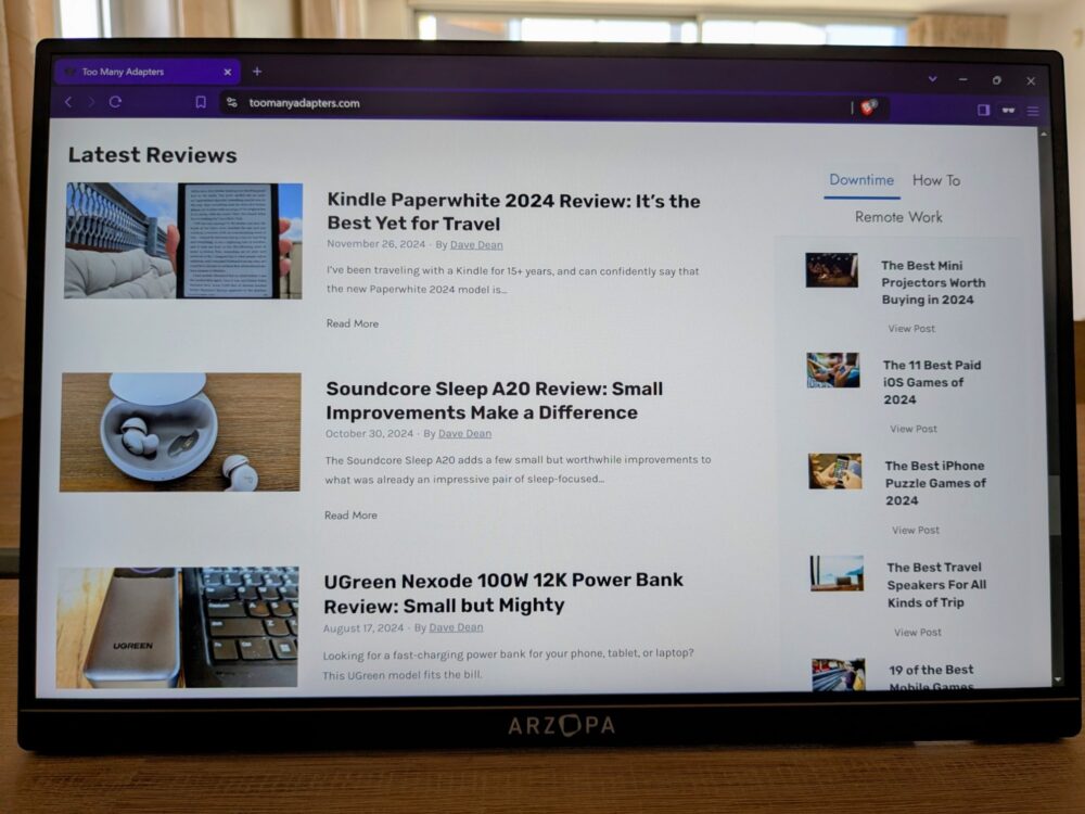 Front-on view of a portable monitor showing a page from toomanyadapters.com