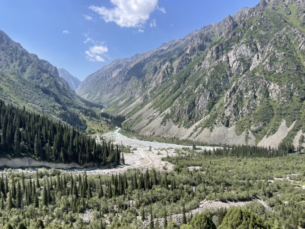 Expansive view down a long river valley flanked by tall mountains on both sides